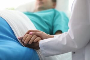 doctor hands hold male hand in hospital